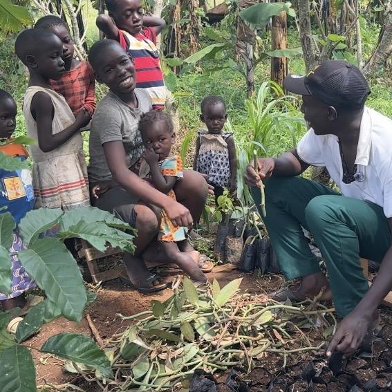 A Garden of We Do steward teaching children to plant on the estate.